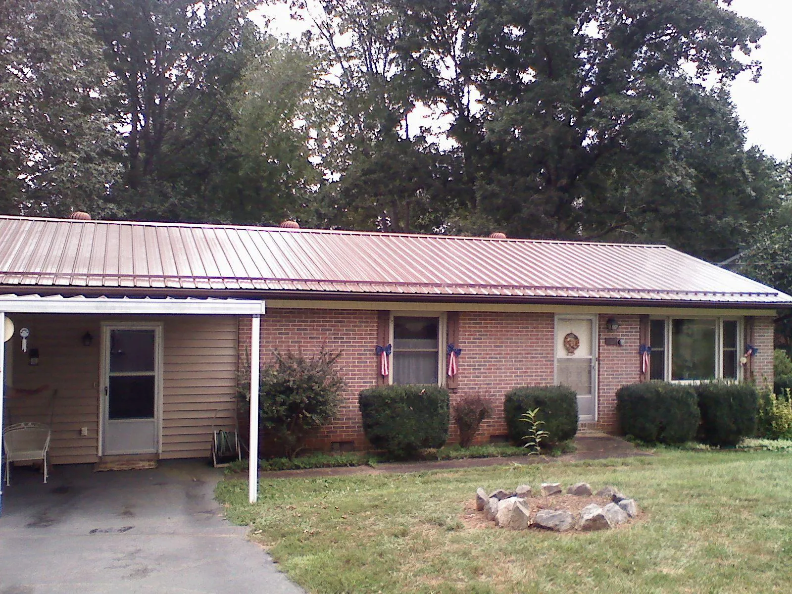 Bronze metal roof and carport on a brick ranch home — Roof Repair work by our crew in Washington